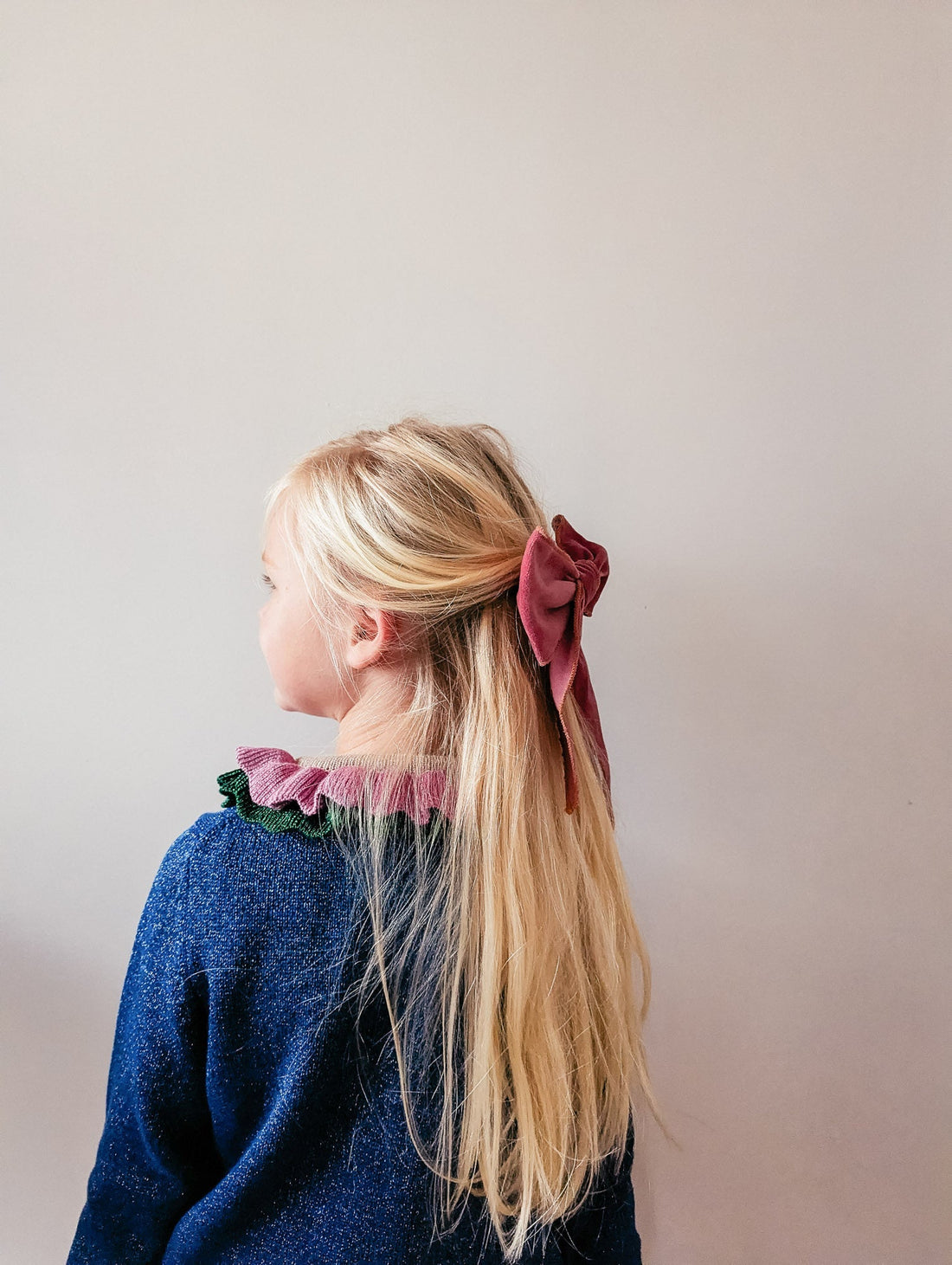 Girl with long blonde hair and pink velvet bow